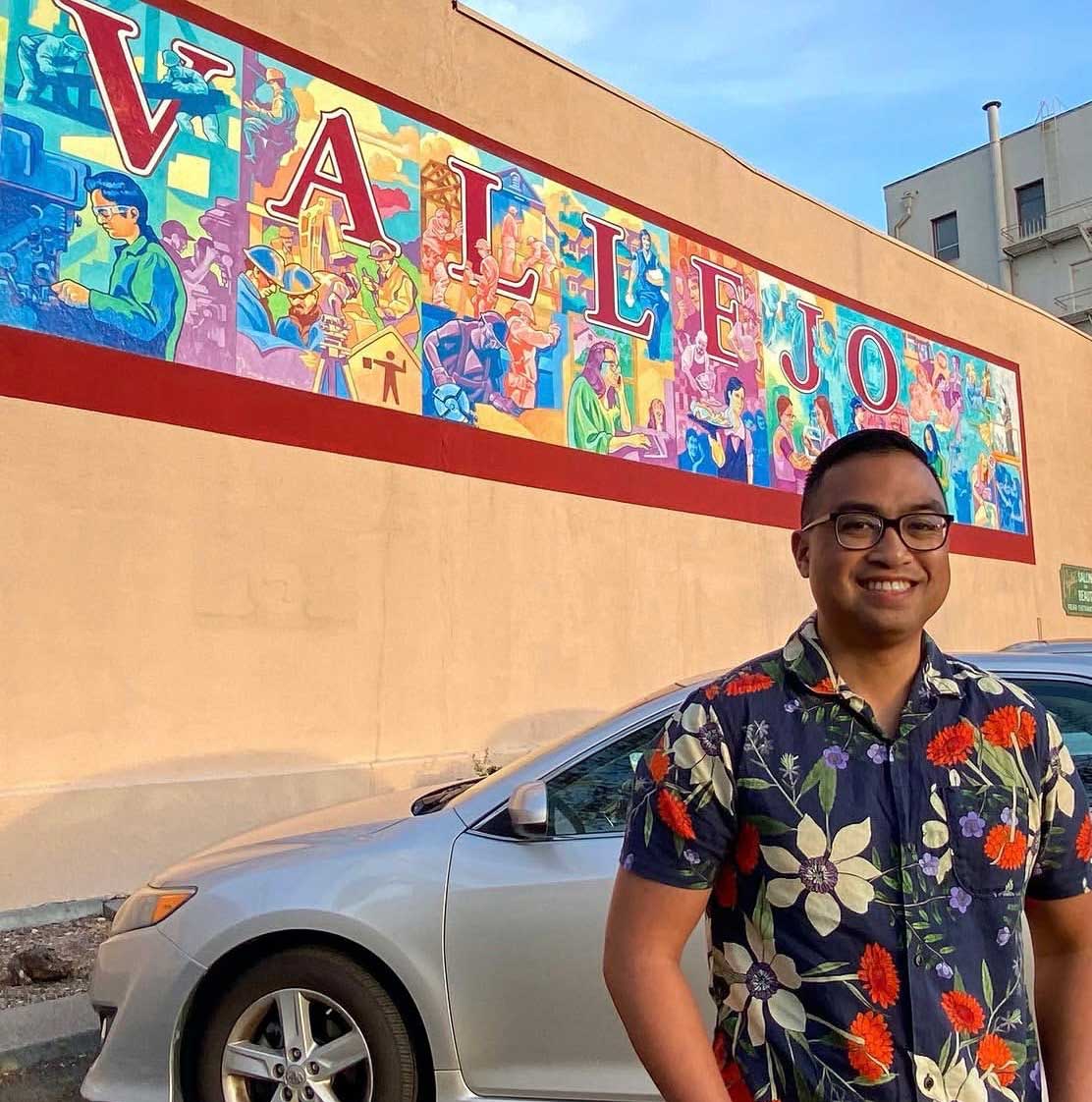 Charles Palmares in front of a 'Vallejo' mural